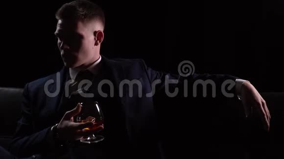 派对上的商人坐在沙发上喝着威士忌视频的预览图
