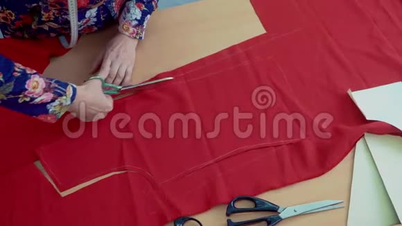 裁缝剪下红色的衣服布料视频的预览图