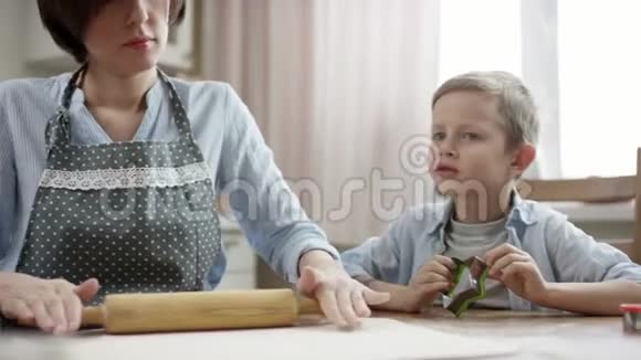 妈妈和儿子一起在厨房的桌子上做饼干视频的预览图