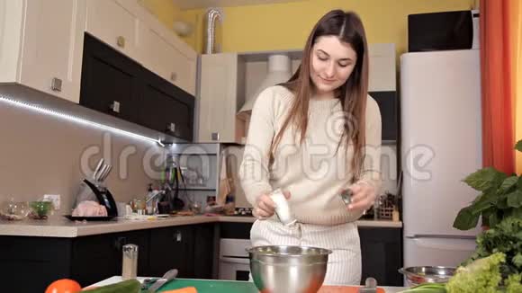 女孩准备了一份蔬菜沙拉和盐浇在上面视频的预览图