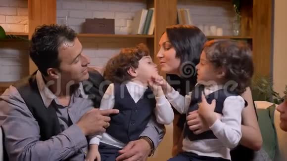 阿拉伯孩子双胞胎在客厅里坐在父母身上互相争斗视频的预览图