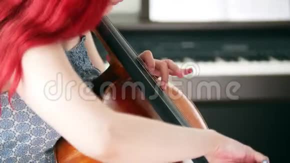 一个有着粉色头发的女人在房间里玩大提琴视频的预览图