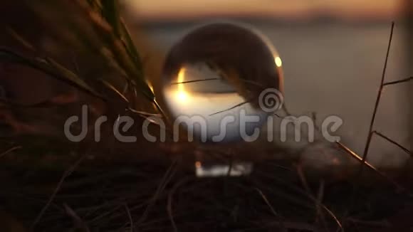 夕阳中的玻璃球在草地上戏剧性地随风飘扬全世界的反思生活方式视频的预览图