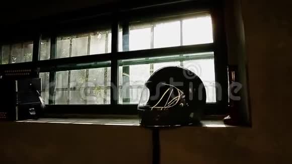骑摩托车的人躺在窗台上头盔的美丽图案透过玻璃阳光明媚视频的预览图