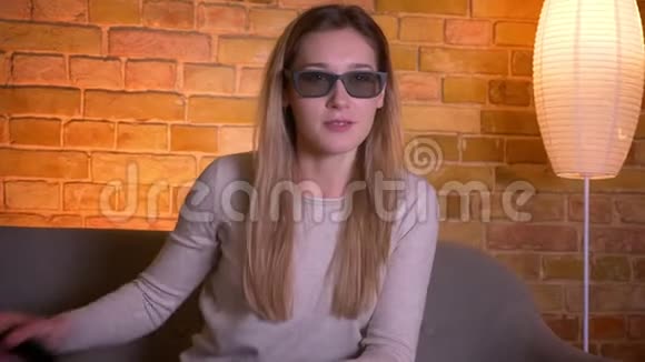 年轻漂亮的白种人深色头发的女性在电视上观看一部3D恐怖电影并获得了一个跳跃镜头视频的预览图