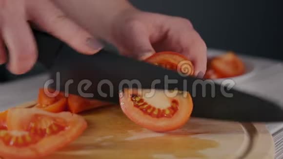 女士用黑色刀切熟番茄视频的预览图