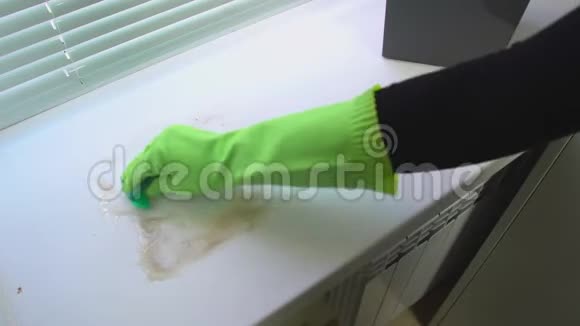 一只手戴绿色防护手套用蓝色潮湿的抹布清洗窗台使其不受灰尘和污垢的影响视频的预览图