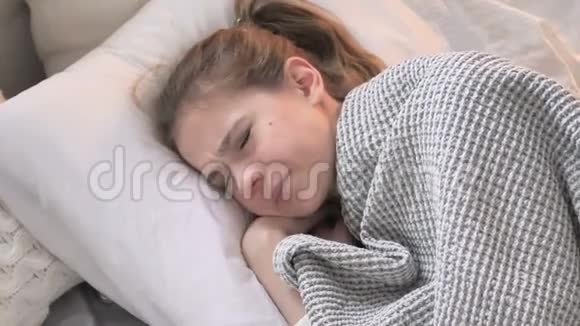 令人不安的年轻女性试图睡在床上视频的预览图