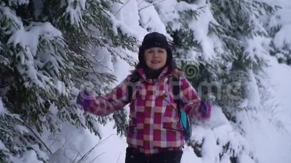 一个年轻的女人独自在雪地里年轻漂亮的游客玩得很开心她高兴下雪了慢动作特写镜头视频的预览图