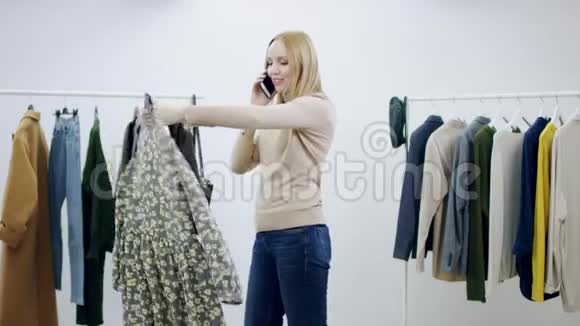 成年美女在试衣间看衣服时用手机说话视频的预览图