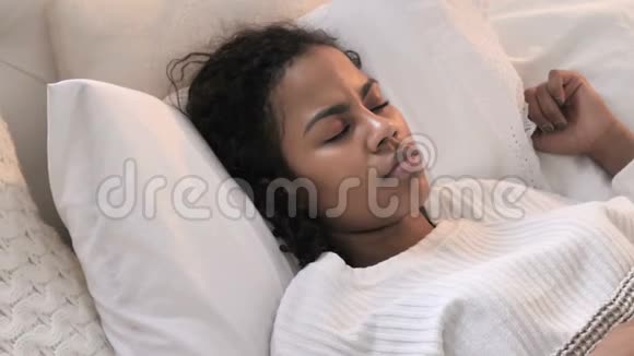 躺在床上睡觉的年轻非洲妇女的最高看法视频的预览图