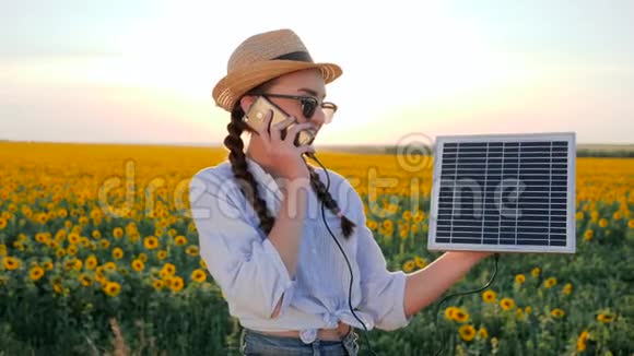 电力生产妇女交谈电话和保持太阳能电池跟踪太阳充电电池清洁能源视频的预览图
