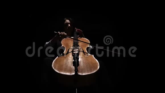 在黑暗的房间里的女孩扮演大提琴排练一篇作文黑色背景基本观点视频的预览图