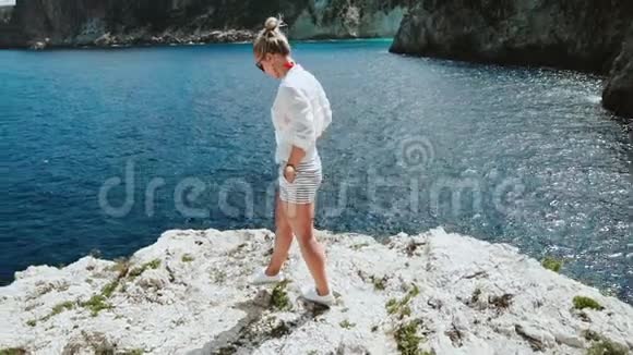 在希腊度假的金发女人沿着白色悬崖散步在头孢洛尼亚凯法洛尼亚欣赏令人惊叹的风景视频的预览图