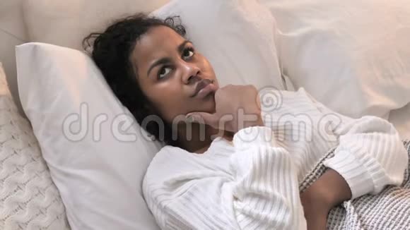 青年非洲妇女躺在床上思考的最高观点集思广益视频的预览图
