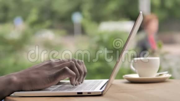 非洲手打字在笔记本电脑键盘户外视频的预览图