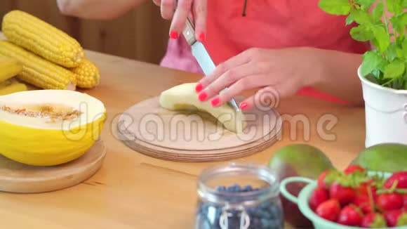穿着粉色上衣的女人切着一个多汁的黄瓜视频的预览图
