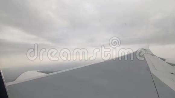 飞机的白翼穿透白云升起蓝天窗外的景色视频的预览图
