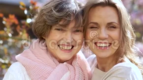 两个美丽的女人老人和年轻人看着镜头笑近景母亲节国际视频的预览图