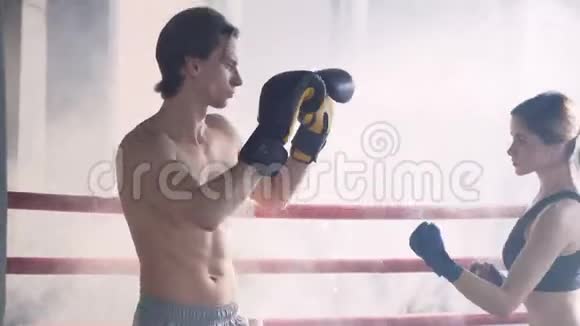 有吸引力的女拳击手训练与男教练在拳击场视频的预览图