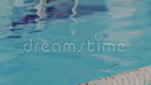 年轻的女运动员从游泳池的水里出来她恢复了呼吸摘下护目镜看着视频的预览图