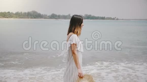令人惊叹的侧景拍摄年轻美丽的快乐女人走在田园诗般的热带海洋海滩放松和休息视频的预览图