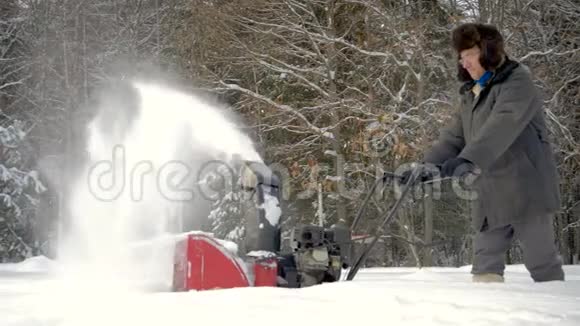 冬季森林背景下白雪皑皑的工人清扫道路视频的预览图