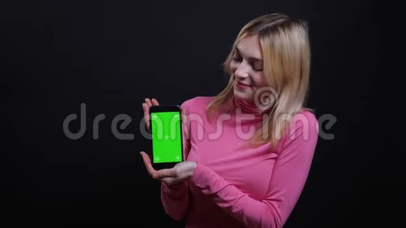 年轻漂亮的金发女性使用手机的特写镜头并显示绿色屏幕应用于相机视频的预览图