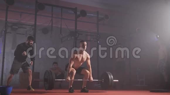 强壮的运动员用体重举起杆子并握住它视频的预览图