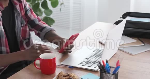 商人在办公室里用手机和笔记本电脑喝咖啡视频的预览图