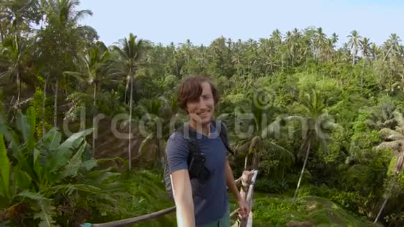 一个年轻人在一个大露台上拍自拍片可以看到丛林视频的预览图