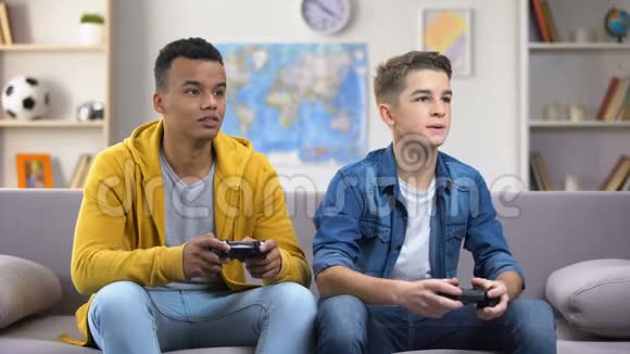 情绪化的欧洲和非裔美国人朋友玩电子游戏闲暇时间视频的预览图