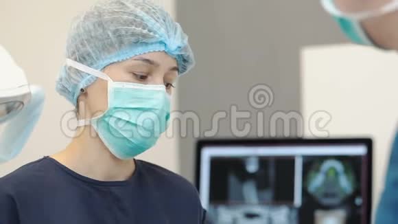 戴口罩的年轻女牙医用工具接近牙医脸视频的预览图