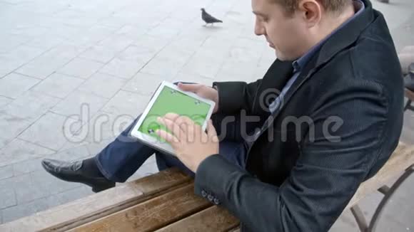 穿西装在长凳上工作的人绿屏视频的预览图