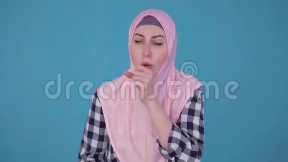 年轻穆斯林妇女在头巾哮喘发作时使用喷雾视频的预览图