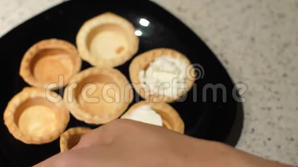 女性的手从盘子里拿出空馅饼用白干酪填满准备零食闭合视频的预览图