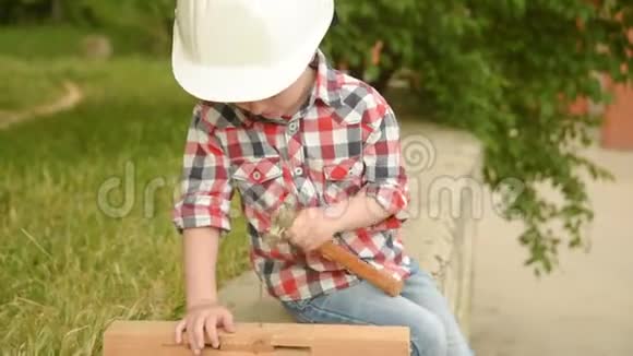 戴着建筑头盔的小男孩用铲子视频的预览图