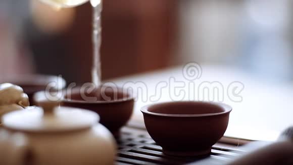 茶壶把茶倒进小杯子里剩下的倒在茶具上视频的预览图