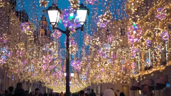 街道装饰有照明圣诞灯花环四处游荡视频的预览图