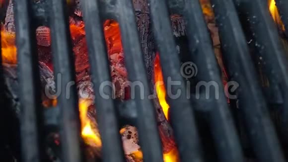 热的灰色烤架上有厚厚的铁棒火焰从酒吧里喷出来特写顶景视频的预览图