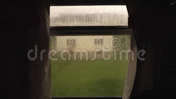 火车车窗玻璃上的雨水滴从移动火车窗口景观山村穆迪电影院视频的预览图