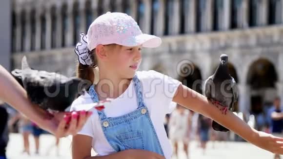 意大利威尼斯2018年7月7日观看快乐的女人和孩子女孩游客抱鸽子喂食和他们一起玩视频的预览图
