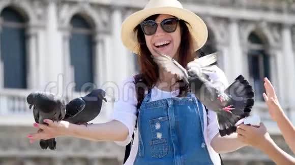 意大利威尼斯2018年7月7日快乐女人的肖像游客抱鸽子喂食和它们一起玩玩得开心视频的预览图