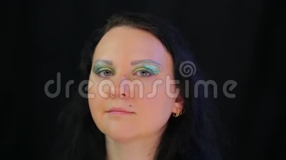 一个肤色浅黑的女人的脸上闪着亮绿色的光芒视频的预览图