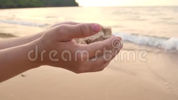 成年女性沙滩上的沙子从手上掉下来视频的预览图