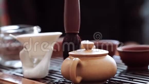 一个特殊的茶刷轻轻地擦拭一个小茶壶的圆圈视频的预览图