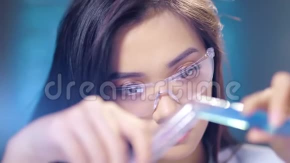 戴眼镜的亚洲女科学家用化学试剂做特写制造保健产品视频的预览图