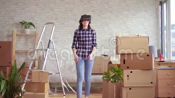在盒子旁边戴着虚拟现实眼镜的年轻女子视频的预览图