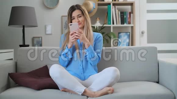 快乐美丽的女孩使用数字移动设备浏览互联网呆在家里享受现代生活视频的预览图