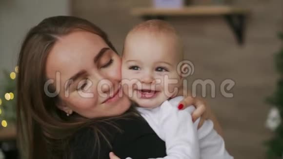 特写妈妈抱着宝宝孩子微笑着看着心爱的妈妈一起站在白色的厨房里视频的预览图